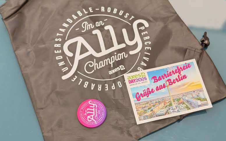 Merchandise Produkte von Axes4 - A11y champion Tasche und Grußkarte mit Text "Barrierefreie Grüße aus Berlin"