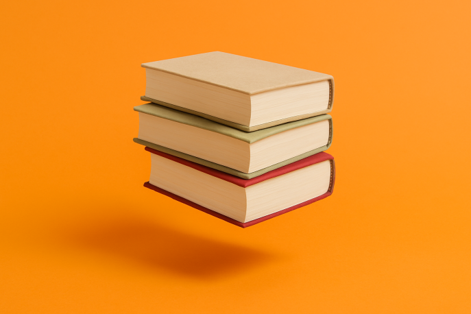 Ein Stapel aus drei dicken, gebundenen Büchern schwebt knapp über einem kräftigen orangefarbenen Hintergrund. Die Bücher liegen sauber übereinander; unter ihnen ist ein weicher Schatten zu sehen, der den Schwebeeffekt betont.